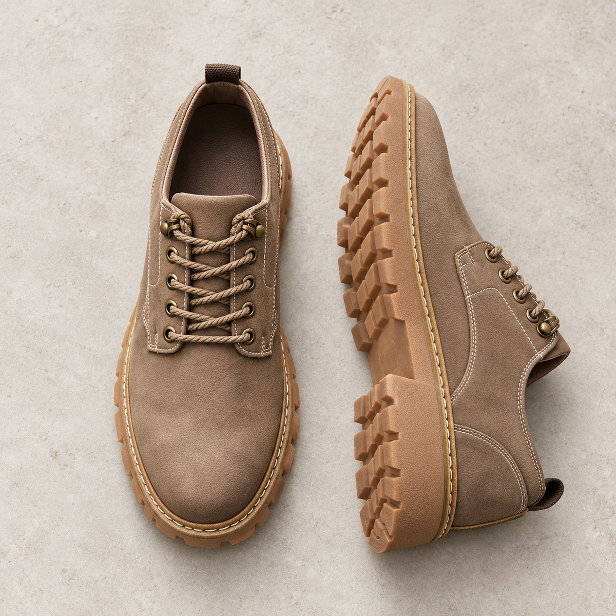 Taupe Ridgeway low boots photographed as a pair on pale limestone, showing the upper and sole.